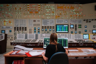 žena za ovládacím panelem dozorny jaderné elektrárny